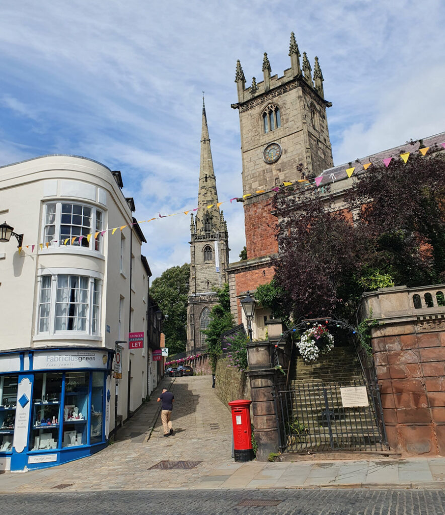 Red telephone box, church towers and street view, Shrewsbury